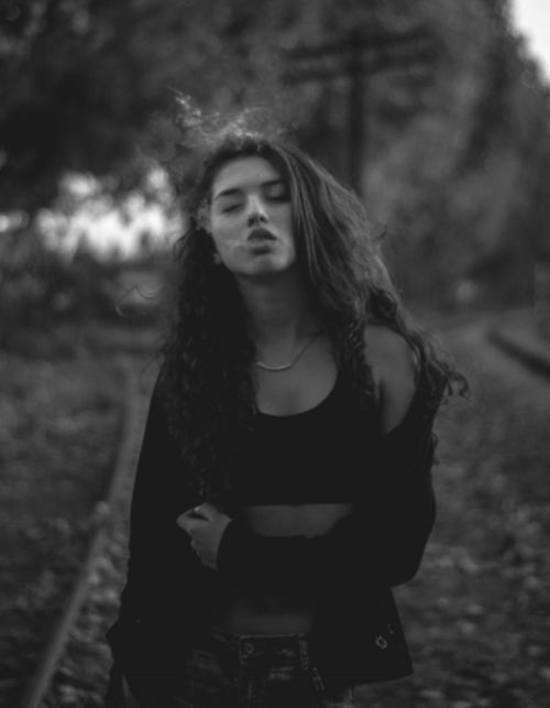 Girl with eyes closed and pot smoke coming out of her mouth